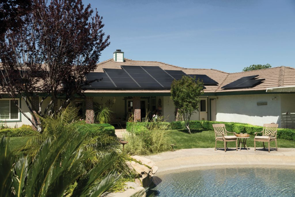 solar panels on roof of nice house with outdoor pond