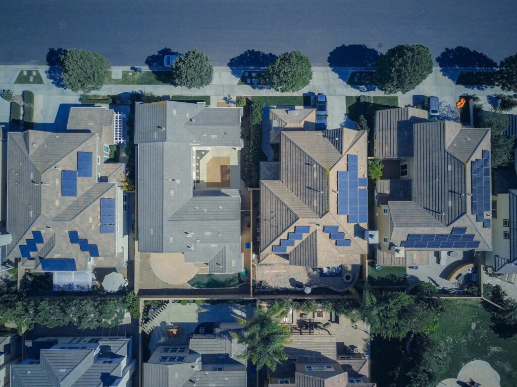 Aerial view of a neighborhood of residential homes with solar panels installed on the roof