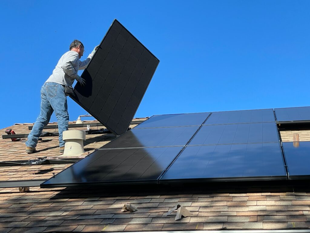 Technician installing solar panels on a home